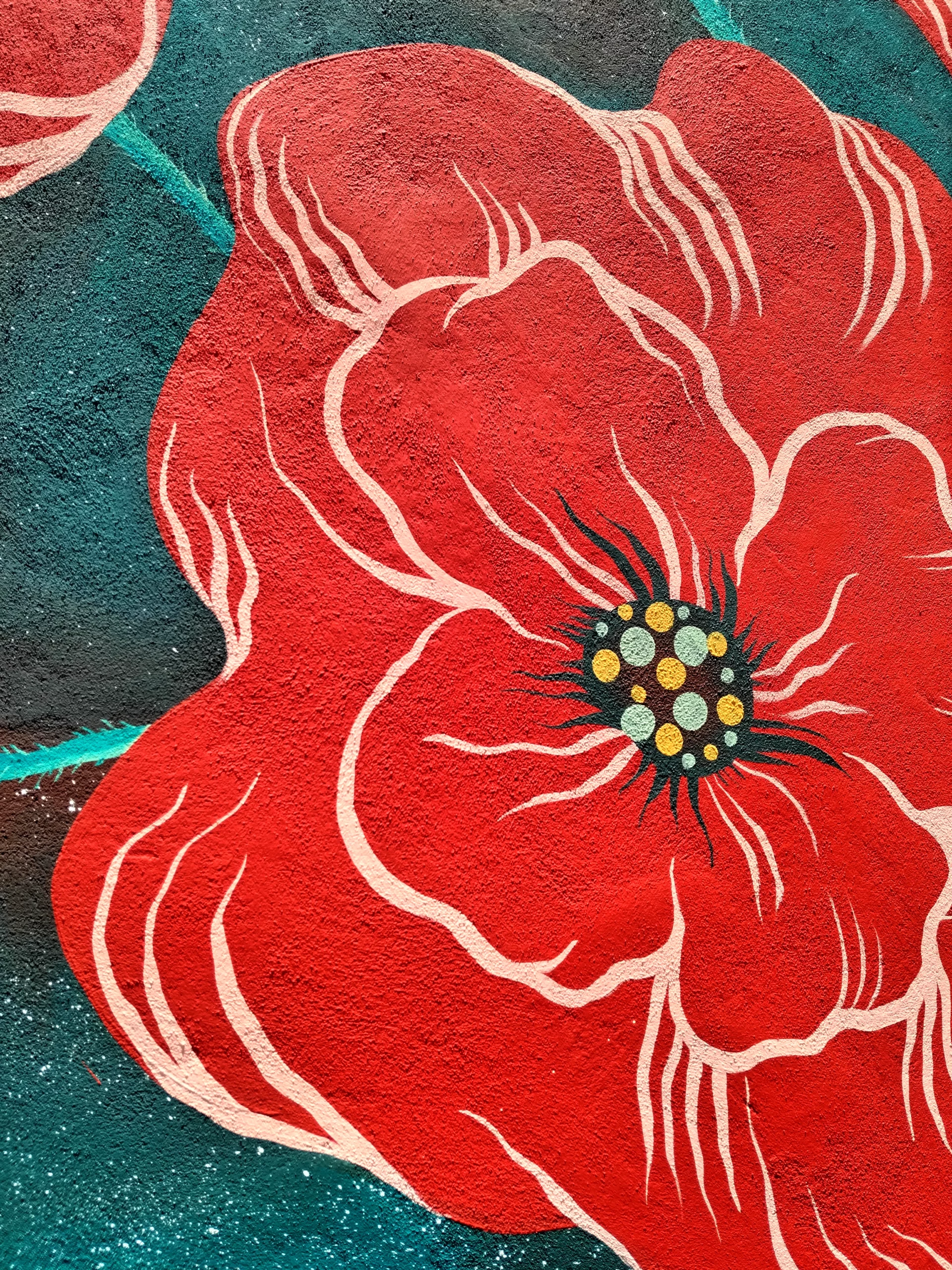 Dettaglio dei papaveri dipinti da Rosmunda nell'opera Qui arde ancora la memoria, il rosso dei petali si staglia sul cielo color ottone.