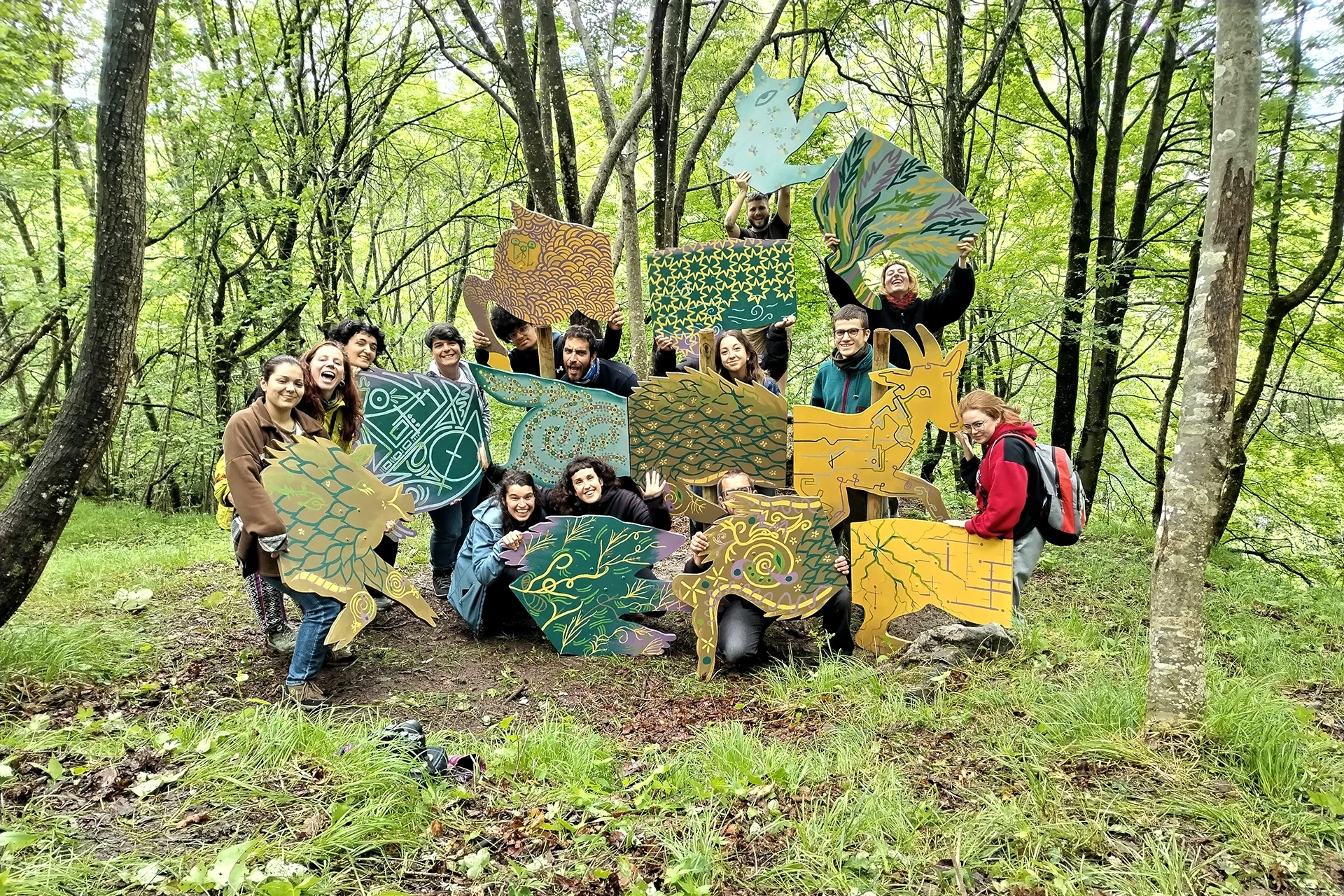 Il gruppo di lavoro posa nel bosco con le sagome decorate del progetto Chimera di Rosmunda.