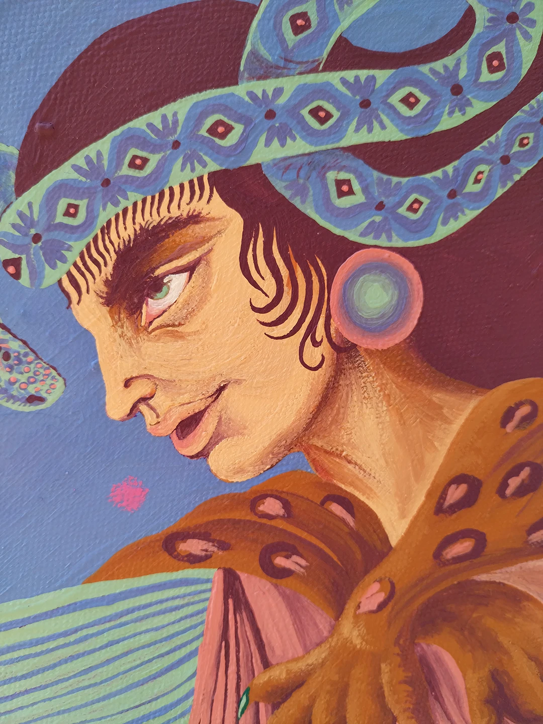 Dettaglio dell'opera "Ekstasis" di Rosmunda che mostra il volto di una figura mitologica con un copricapo ceruleo decorato da motivi romboidali e un serpente stilizzato. L'espressione è intensa e fiera, caratterizzata da toni caldi della pelle che contrastano con lo sfondo blu vibrante della tela.