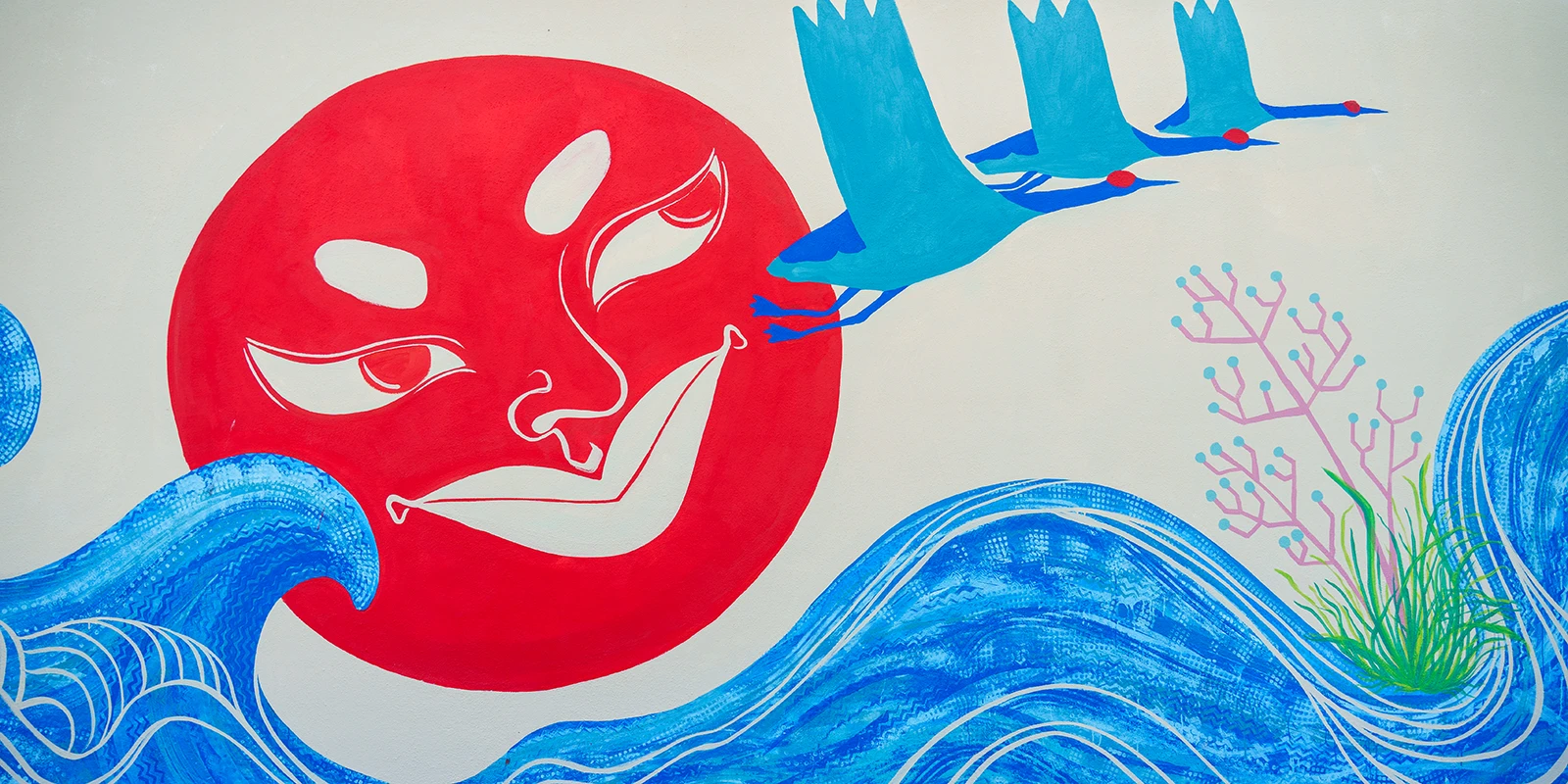 Copertina orizzontale del murale per Toyota: un grande sole rosso dal volto umano stilizzato che sorge tra onde blu, accompagnato da tre gru in volo e una pianta corallina rosa e verde