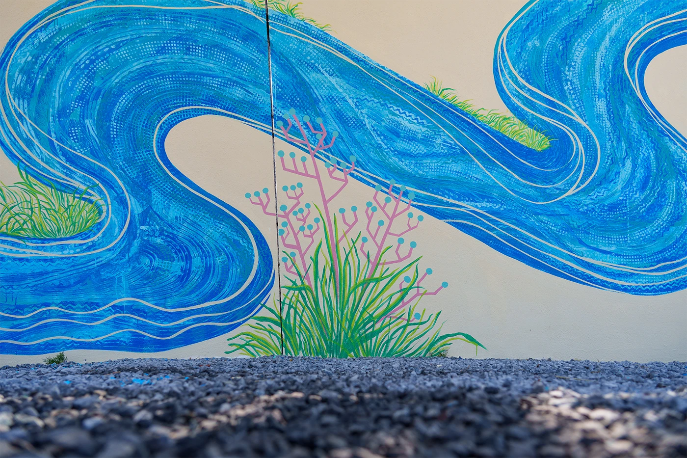 Dettaglio del murale per Toyota che ritrae un arbusto marino stilizzato con rami rosa e foglie verdi, circondato da onde blu con pattern a puntini e linee dinamiche.