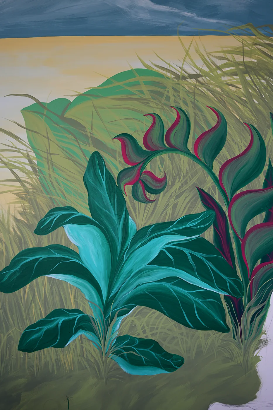 Dettaglio verticale del murale Embrace Your Fears di Rosmunda che mostra una lussureggiante vegetazione tropicale con foglie di un verde intenso e una pianta esotica dai fiori fucsia e rosa, dipinta su uno sfondo che sfuma verso un cielo dorato.