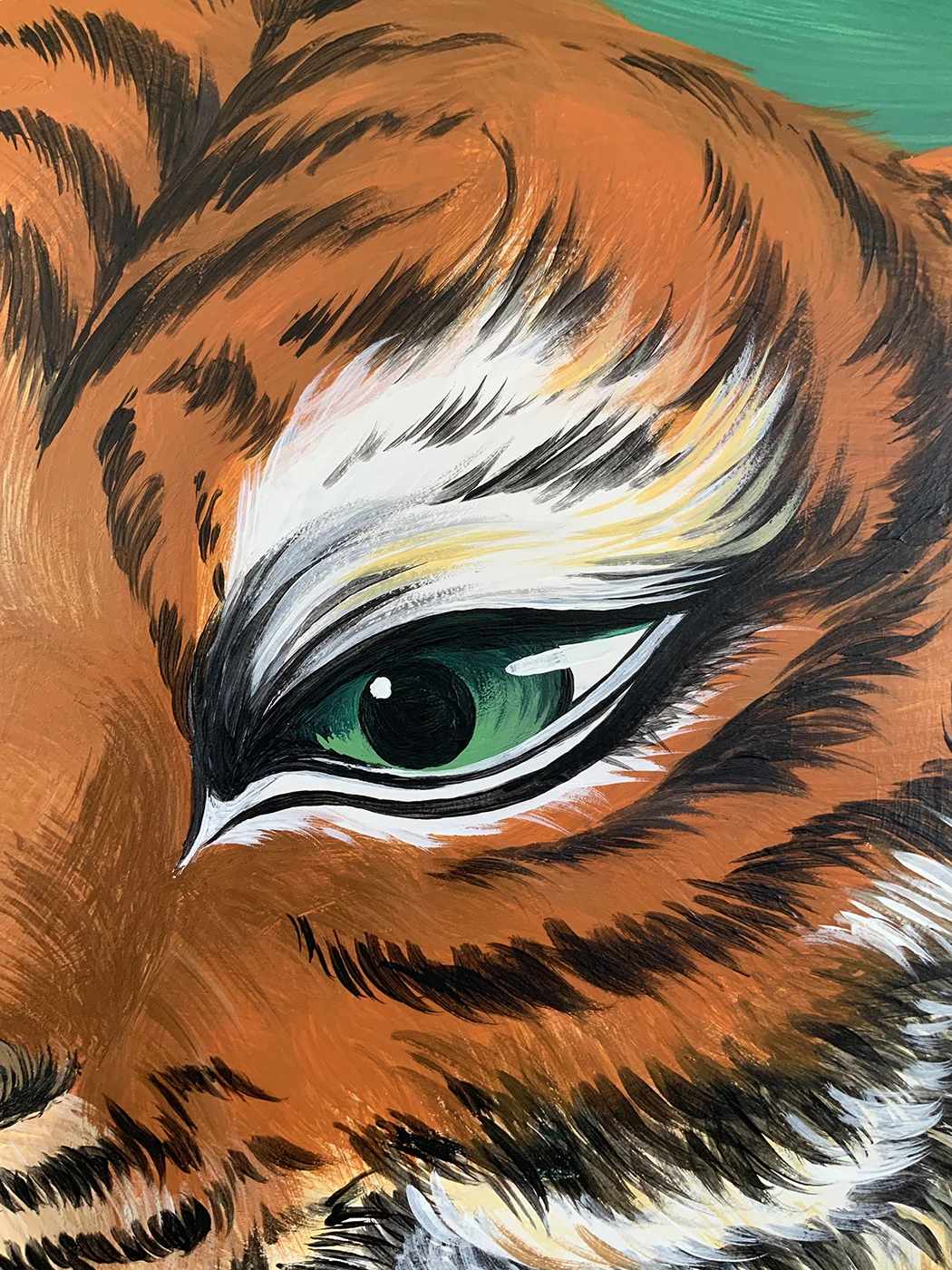 Dettaglio del murale Embrace Your Fears di Rosmunda che mostra in primo piano l'occhio verde e parte del manto striato di una tigre, reso con pennellate cariche di nero, arancione e bianco.