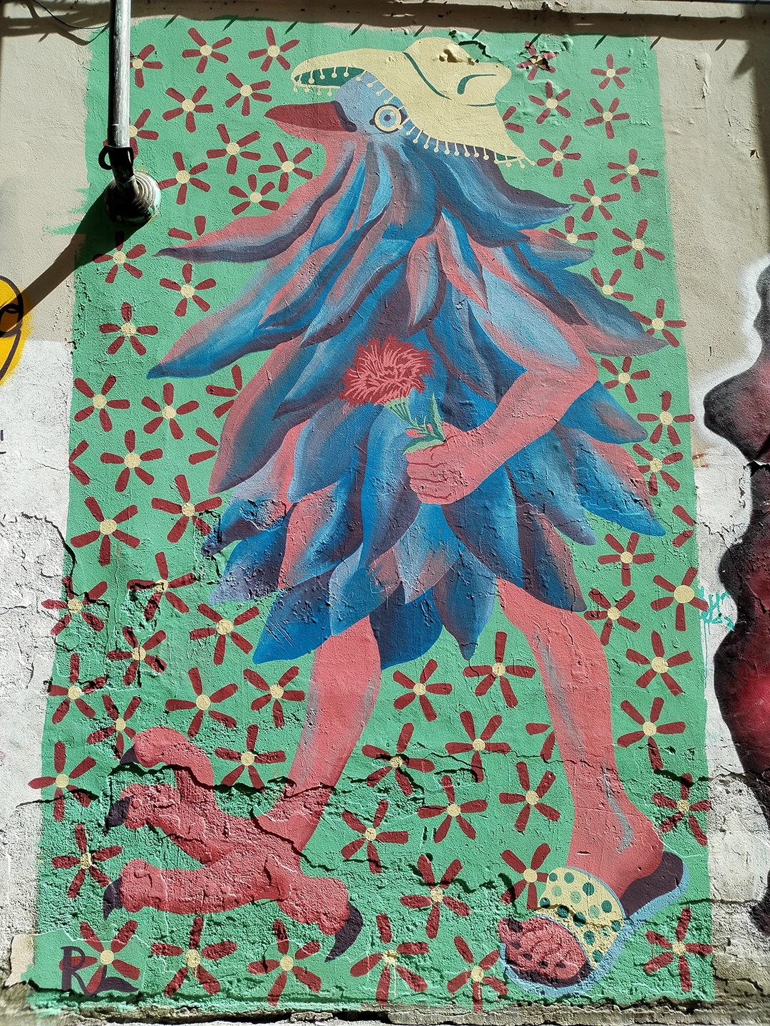 Dettaglio del murale 'Piccione Viaggiatore' di Rosmunda che ritrae la zampa di un uccello stilizzata nei toni del rosa e del rosso, immersa in un pattern di piccoli fiori gialli e rossi su uno sfondo verde menta.